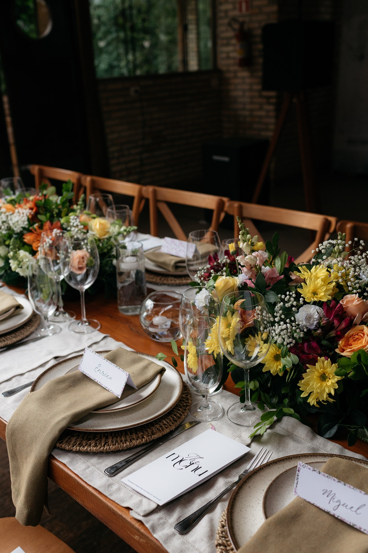 Mise en place sofisticado com louças finas, taças de cristal e flores